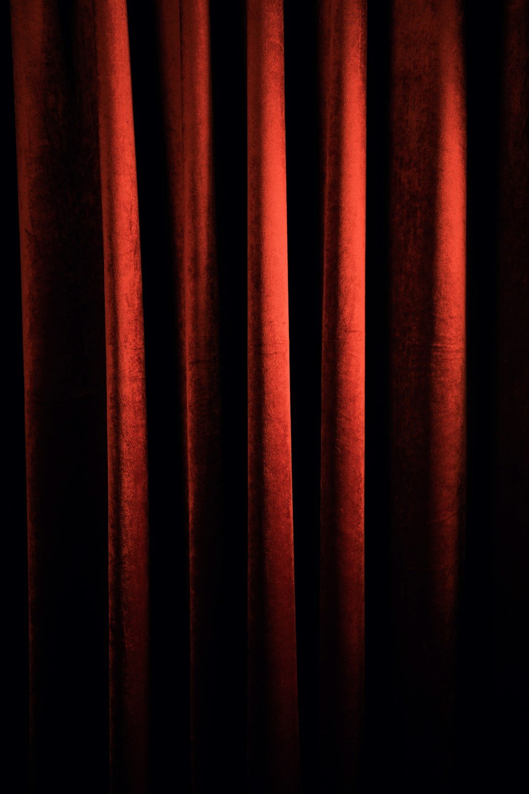 Ornate theatre stage with red velvet curtains and warm lights